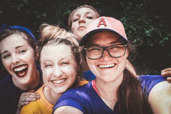 Three women smiling and posing for a selfie together.